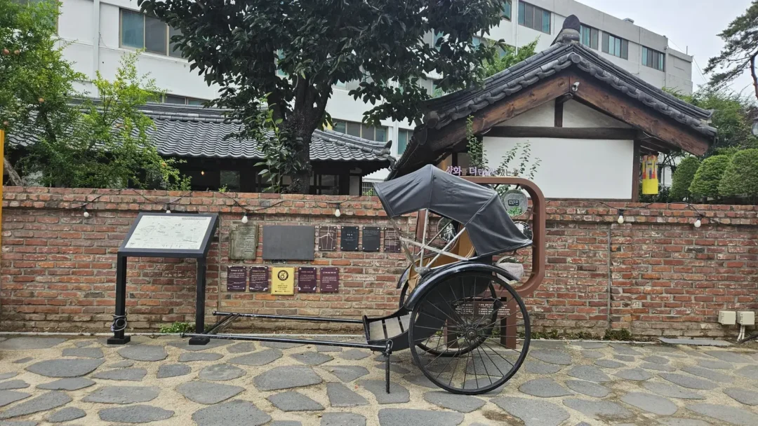 이상화 고택 붉은 벽돌 담장 앞의 검은 인력거