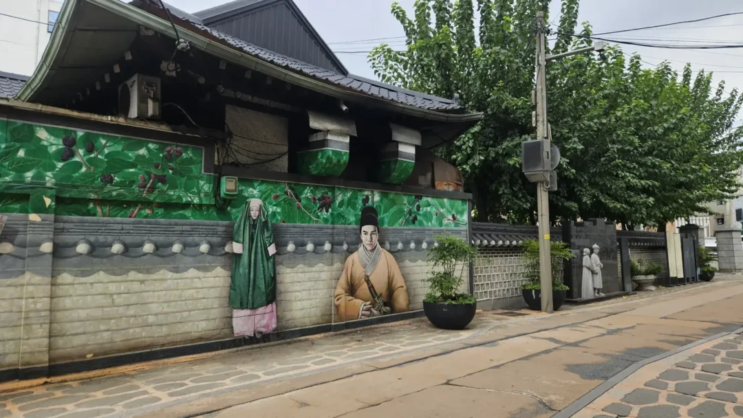 뽕나무 잎과 오디, 장옷 입은 여인과 관복 차림 인물을 그린 뽕나무골목 벽화